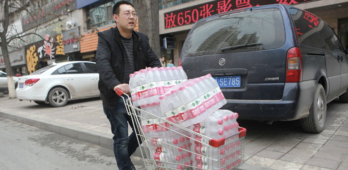 A man pushes a shopping cart filled with bottled water after reports on heavy levels of benzene in local tap water, in Lanzhou, Gansu province.