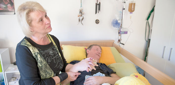 CARING: Diana Schmitt, left, holds the hand of her husband Ruediger, who has been in a persistent vegetative state for the past 14 years. She is a co-
