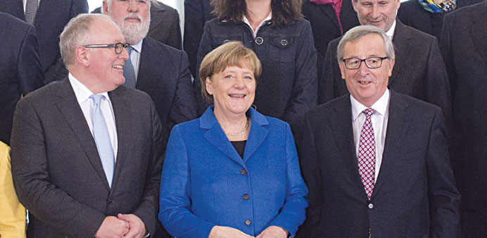German Chancellor Angela Merkel poses for a picture with First Vice-President of European Commission Frans Timmermans (left) and EU Commission Preside