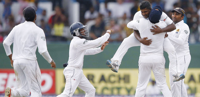 Sri Lankau2019s Rangana Herath (top) celebrates with captain Angelo Mathews, Mahela Jayawardene (right), Kaushal Silva (left) after taking the wicket of P