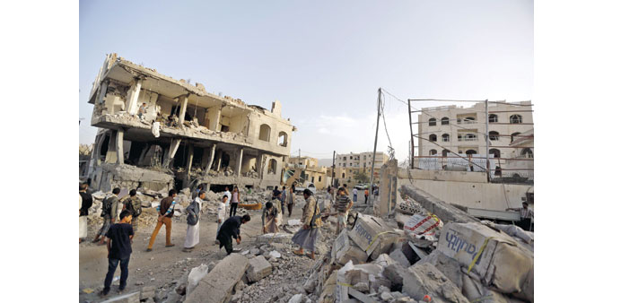 People stand at the site of an air strike in Sanaa yesterday.