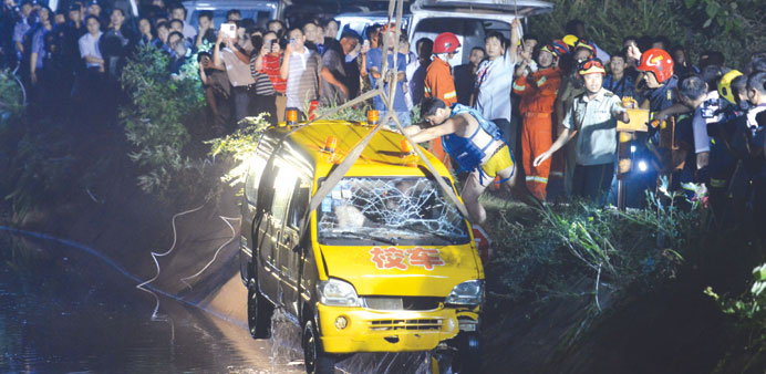 Rescuers pull out a school bus after it crashed into a pond on the way from a kindergarten in Xiangtan, central Chinau2019s Hunan province yesterday