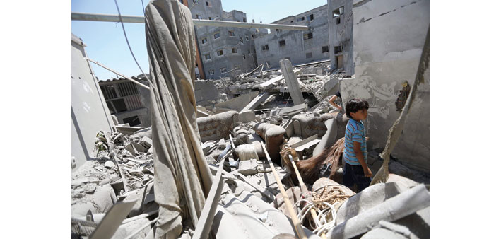 A  boy inspecting the rubble of his destroyed house after an Israeli strike, in Jabaliya refugee camp, northern Gaza Strip, yesterday.