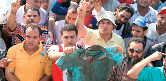 Supporters of Mursi show a bloodstained shirt of one of the victims.