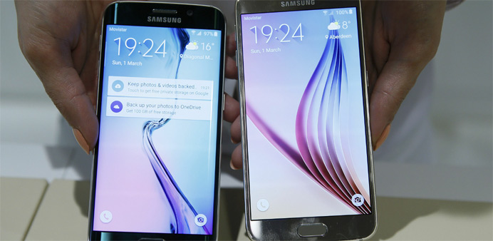 A hostess displays the Galaxy S6 edge (L) and Galaxy S6 smartphones