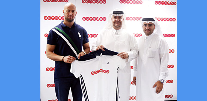 Officials holding a uniform with Ooredoou2019s logo.