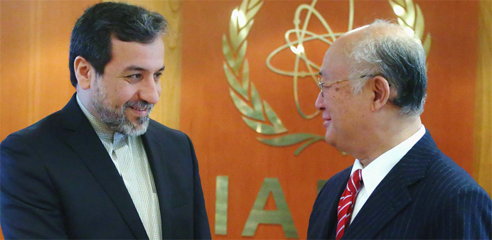 International Atomic Energy Agency (IAEA) Director General Yukiya Amano (R) welcomes Iran's chief nuclear negotiator Abbas Araghchi 