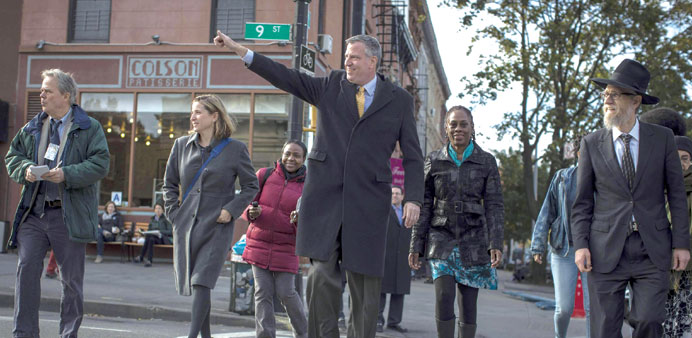 Democratic New York City mayoral candidate Bill de Blasio and his wife Chirlane McCray (centre right) walk to vote in the Park Slope section of Brookl