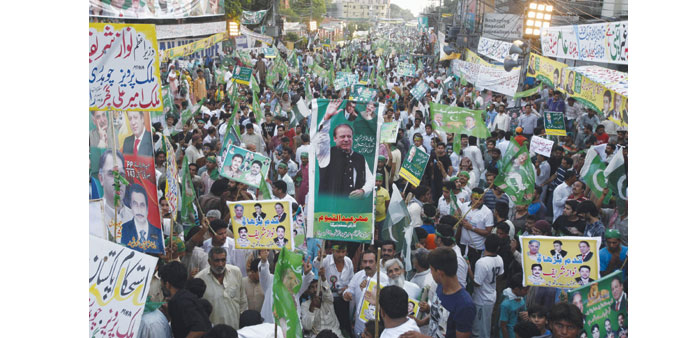 Supporters of Pakistan Muslim League-Nawaz carry posters and national flags as they participate in pro-government rally in Lahore.