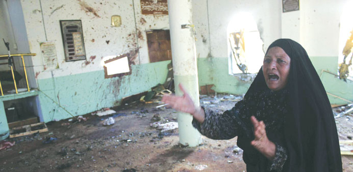 A woman reacts inside the mosque after the bomb attacks in Baquba yesterday.