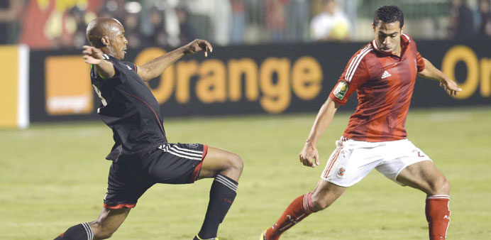Egyptu2019s Ahmed Fathi (R) of Al-Ahly vies for the ball with Collins Mbesuma of the South African Orlando Pirates during the African Champions League sec