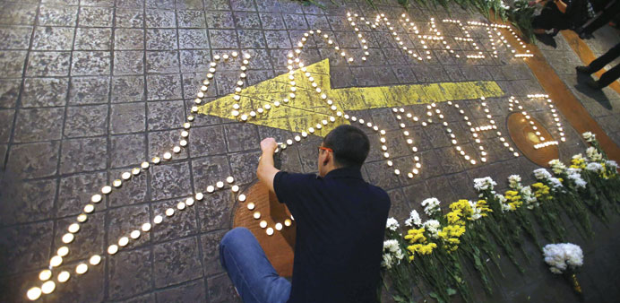 A man lights a candle at a vigil for victims of the downed Malaysia Airlines Flight MH17 airliner, in Subang Jaya outside Kuala Lumpur.