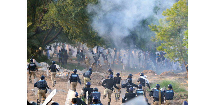 Riot police running towards supporters of Imran Khan and Tahir-ul-Qadri during clashes near the prime ministeru2019s residence in Islamabad yesterday.