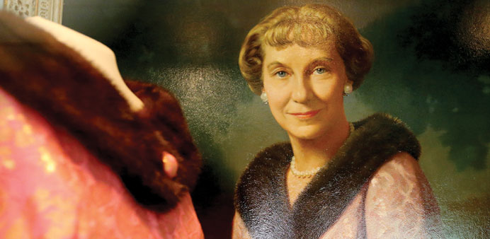 An oil painting of Mamie Eisenhower hangs beside the fur collared gown she wore for the portrait, at the Eisenhower Library.