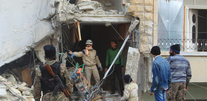 A civil defence member gestures towards a rebel fighter as they search for survivors at a site hit by what activists said were airstrikes carried out 