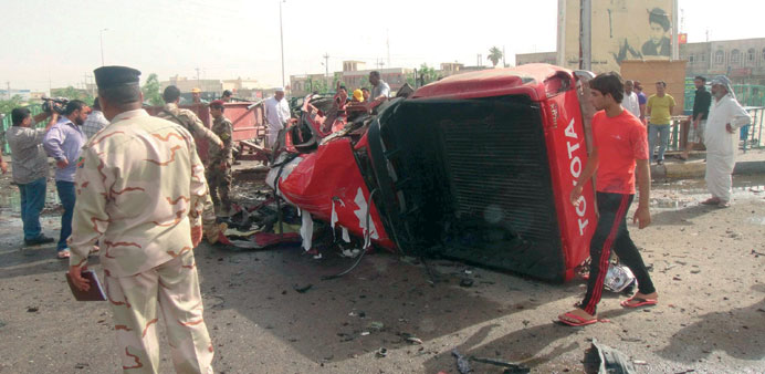 A soldier inspects a damaged truck after a car bomb attack near a market in Basra yesterday.