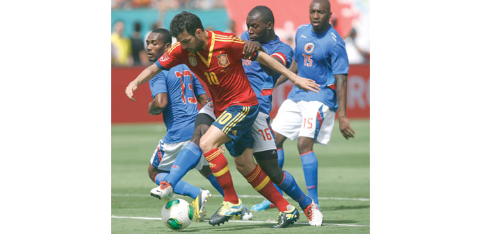 Spainu2019s Cesc Fabregas (centre) dribbles past Haitiu2019s Constant Monuma (left) and Jean-Marc Alexandre (second from right) during their exhibition match 