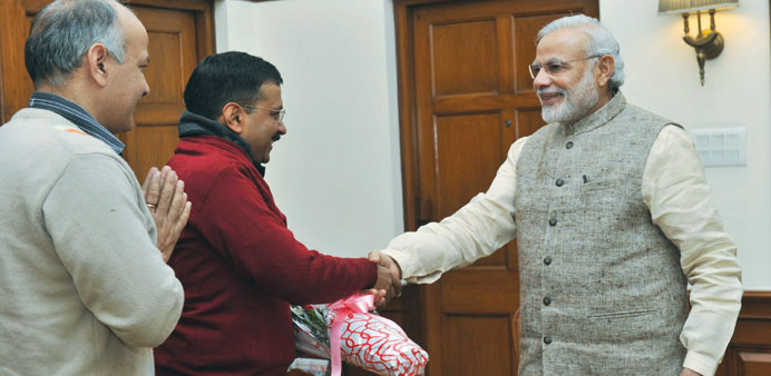 Prime Minister Narendra Modi shakes hands with Delhi chief minister-elect Arvind Kejriwal as AAP leader Manish Sisodia looks on during their meeting i