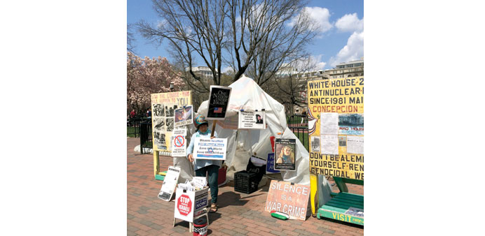 SOLDIERING ON: Spaniard Concepcion Picciotto at her shed outside the White House, holding her protest placards.                                Photo b