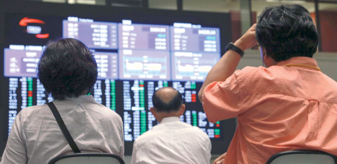    Investors watching price movements on the Tokyo Stock Exchange in Japan yesterday. The Nikkei 225 index lost 469.80 points to 14,142.65 in yesterda