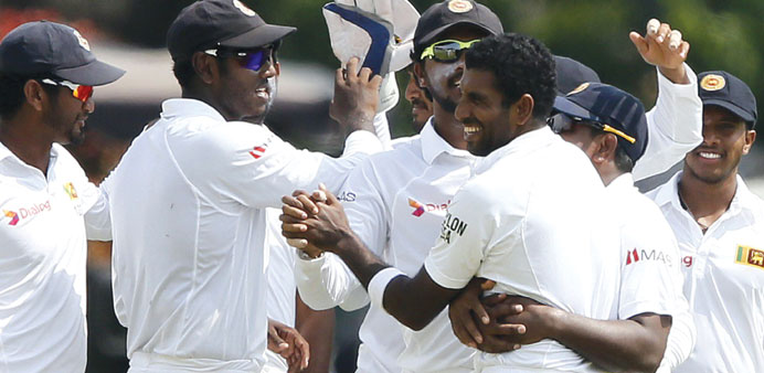 Sri Lankau2019s Dhammika Prasad (right) celebrates a wicket yesterday.