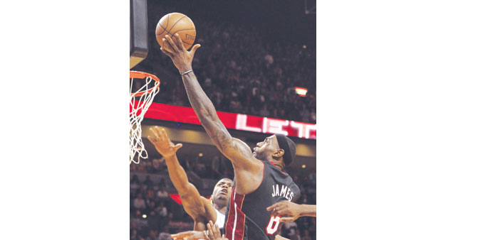Miami Heat forward LeBron James (R) scores the winning basket in the final seconds of their NBA basketball game against the Orlando Magic at the Ameri