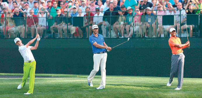  Guan Tianlang of China, Dustin Johnson of the United States and Tiger Woods of the United States all hit a shot at the same time on the 16th hole dur
