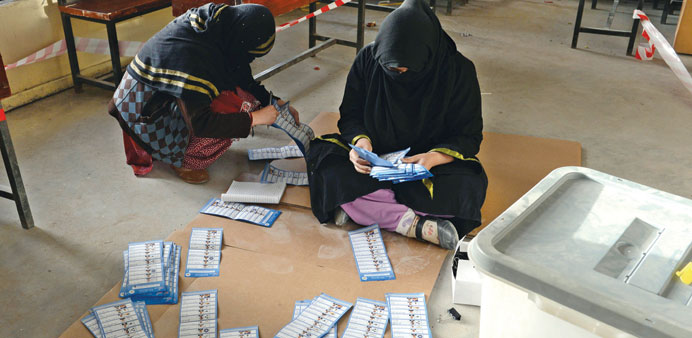 Female Afghan election officials count ballot papers at the end of polling in Kandahar yesterday.