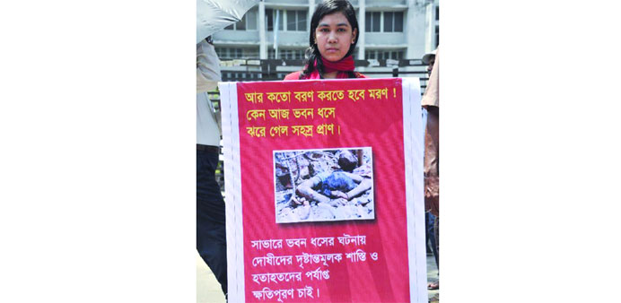 A woman garment worker holding a banner during a protest demanding proper compensation in Dhaka