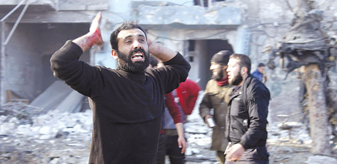 A man with a bloodstained hand reacts at a bombarded site in Aleppo yesterday.