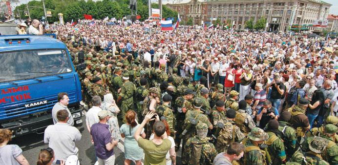 Separatist militants from the u2018Vostoku2019 (East) guard an anti-election rally in the centre of eastern Ukrainian city of Donetsk yesterday.