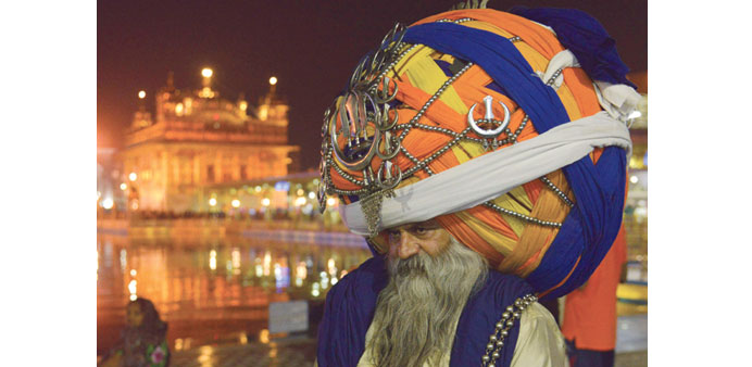 Sikh Nihang (a traditional Sikh religious warrior) Baba Avtar Singh wears an oversized giant traditional turban as he pays respects at the Golden temp