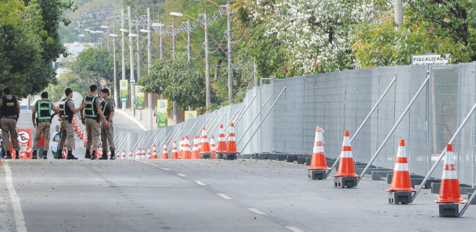 Police stand next to a security fence which has been erected on the roads leading to the Mineirao Stadium in Belo Horizonte, Brazil, yesterday.