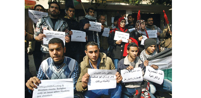 Palestinian youth hold signs during a rally outside the offices of the US humanitarian organisation CARE in Gaza City yesterday.
