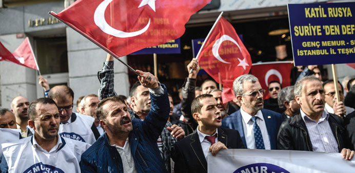 A protester waves Turkeyu2019s national flag while others shout slogans in front of the Russian consulate in Istanbul during a demonstration against Russi