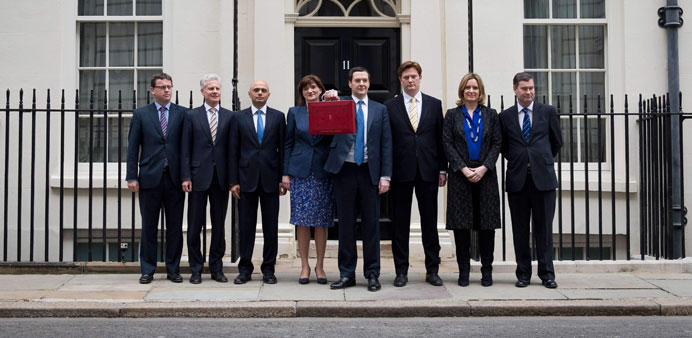 Chancellor of the Exchequer George Osborne poses with his Treasury team holding the budget box outside 11 Downing Street in London yesterday.