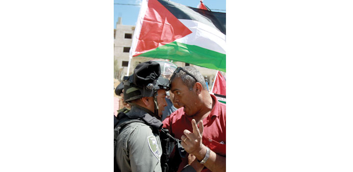 A Palestinian protester scuffles with an Israeli border policeman during clashes in Beit Jala yesterday.