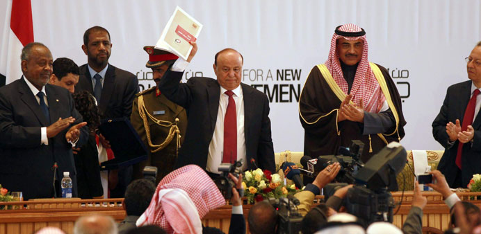 Yemenu2019s President Abd-Rabbu Mansour Hadi shows the book of the national dialogue at the end of a conference aimed at drafting a new constitution and e