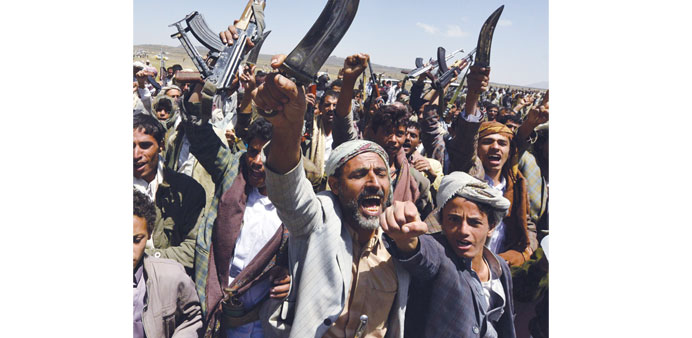 Armed men loyal to the Shia Houthi movement hold their weapons in the air during a tribal gathering demanding the dismissal of the government in Hamda