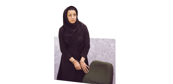 A picture taken on July 8, 2007 shows Reyhaneh Jabbari standing handcuffed at police headquarters in Tehran after she was arrested.