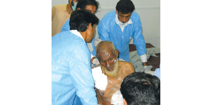 Pakistani medical staff treat an injured blast victim at a hospital following twin bomb attacks in the Dargai area of Pakistanu2019s northwestern Malakand