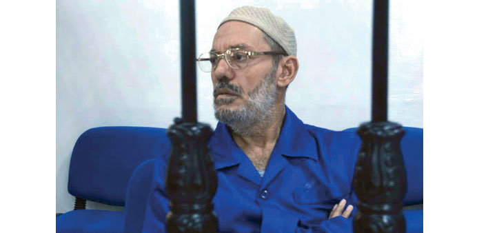 Ibrahim sits behind bars during the hearing in Misrata yesterday.