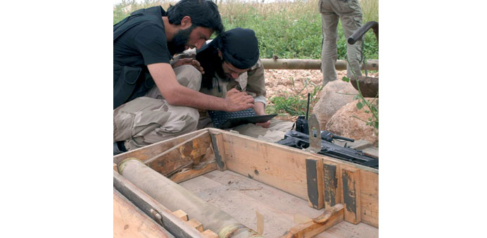 Free Syrian Army fighters work on a computer beside an artillery shell in Aleppou2019s countryside on Friday.