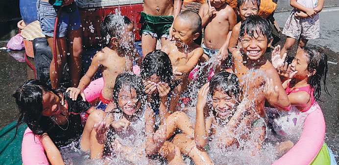 With the onset of summer, Filipino children play in an inflated swimming pool in a slum area of Manila.