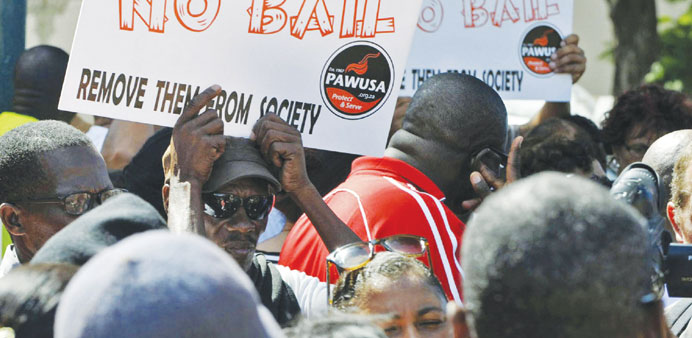 Activists hold placards during a protest outside the magistrateu2019s court in Bredasdorp yesterday.