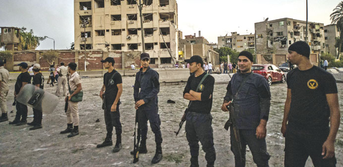 Egyptian riot policemen stand in front of the damaged national security building in northern Cairou2019s district of Shubra yesterday morning.