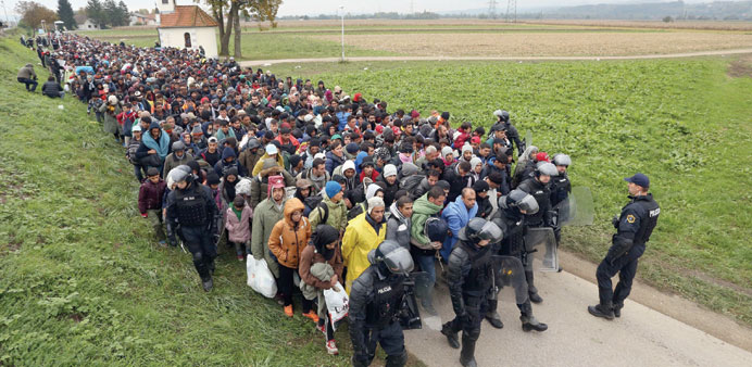 About 1,000 migrants are escorted by Slovenian police officers from the border crossing with Croatia near the village of Rigonce, to Dobova in Sloveni