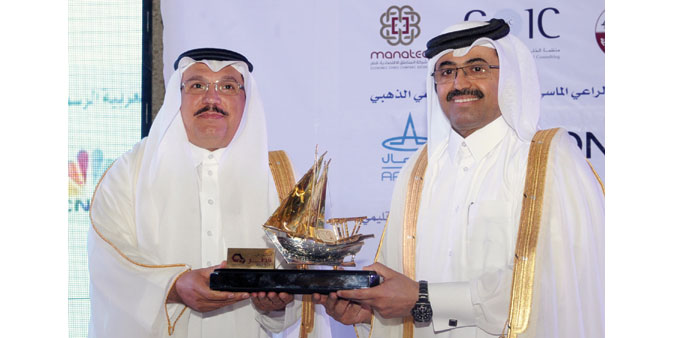 Al-Ageel presents a token of recognition to HE Dr al-Sada at the u201cInvest in Qatar 2015u201d forum. PICTURES: Shemeer Rasheed