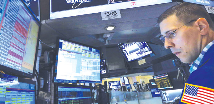 A trader works on the floor at the New York Stock Exchange yesterday. Wall Street fell in midday trade yesterday with the Dow Jones Industrial Average
