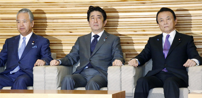 Japan's Prime Minister Shinzo Abe (C), accompanied by Finance Minister Taro Aso (R) and Economic Revitalization Minister Amari Akira (L)